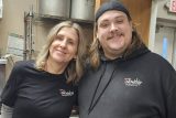 Two people in Fellowship Missions shirts stand together in a kitchen.