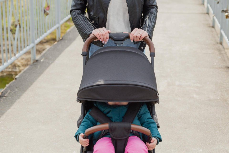 Adult pushing a stroller with a child, supporting ending homelessness in Warsaw.