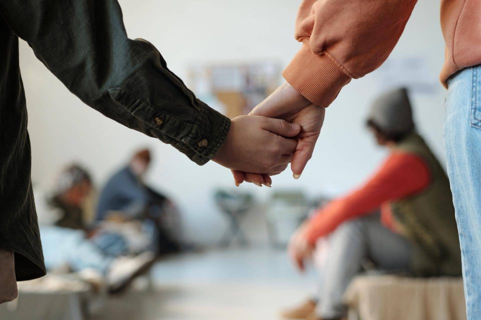 Two people hold hands, symbolizing domestic violence support in the foreground.