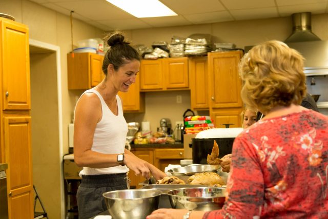 People cooking together in a kitchen, preparing food.
