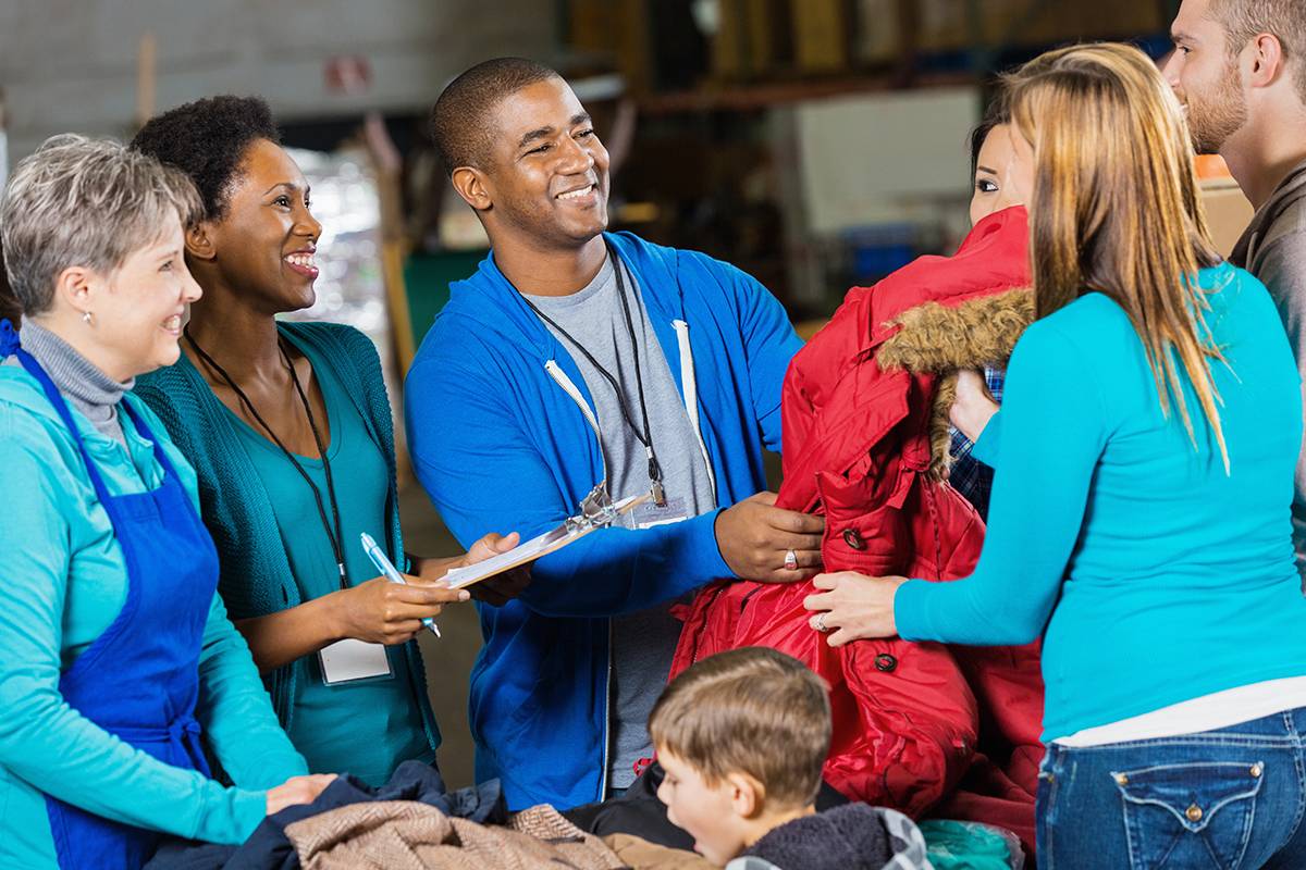 homeless shelter volunteers handing out coats